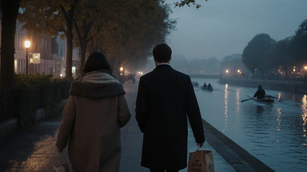 Two people walking along the Thames in Richmond at twilight, autumn leaves and water reflections.