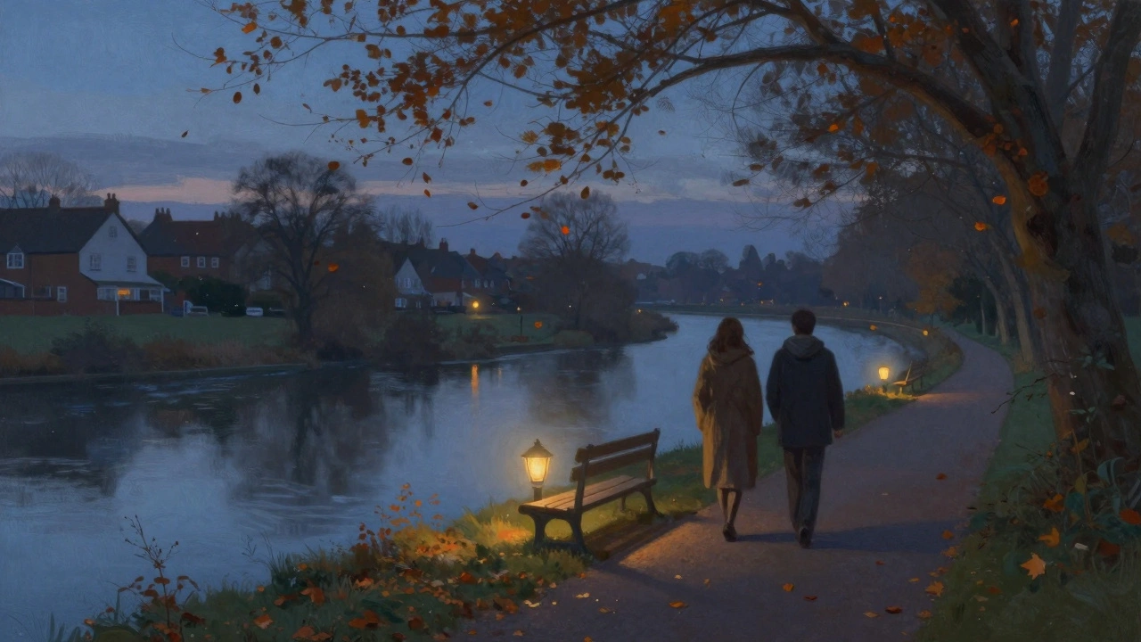Two people walking peacefully along the River Roding in Becontree at dusk, autumn leaves falling gently.