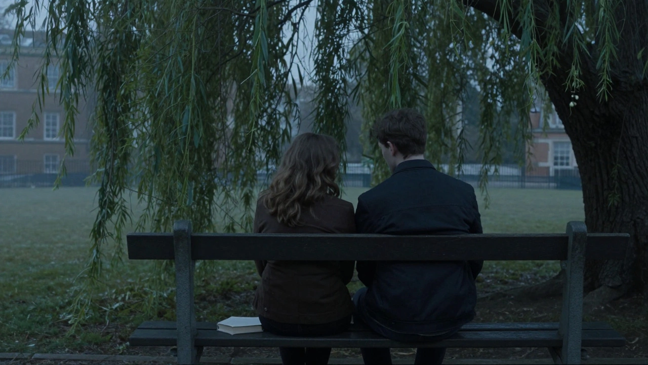 A couple sitting silently on a park bench beneath a willow tree at dusk, sharing a quiet moment in the city.