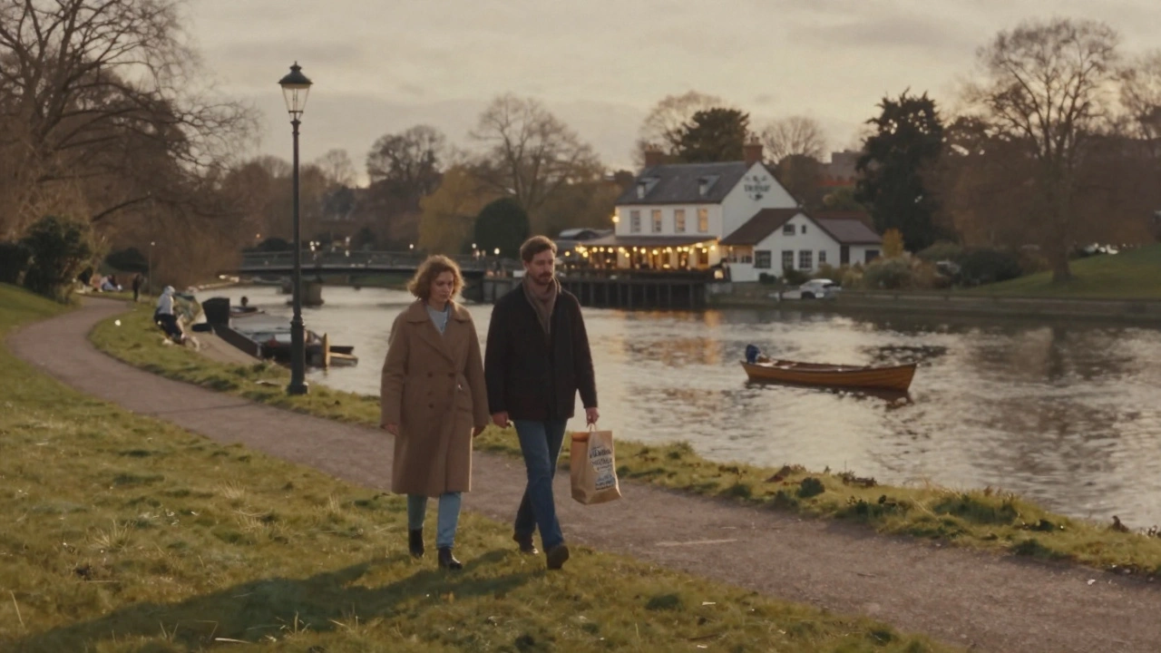 A couple walking along the Thames in Richmond at sunset, with The White Swan pub in the distance.