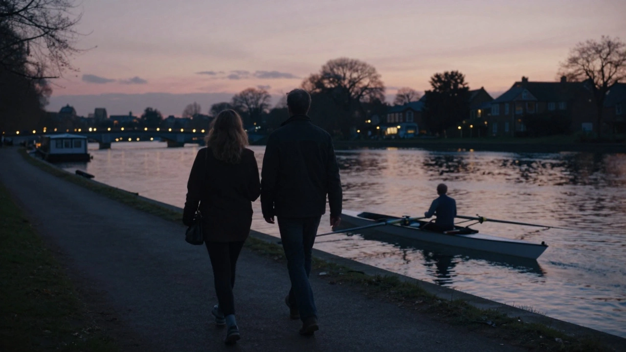 A quiet walk along the Thames at Twickenham at dusk, with soft lights glowing across the water and a rowing boat gently swaying.
