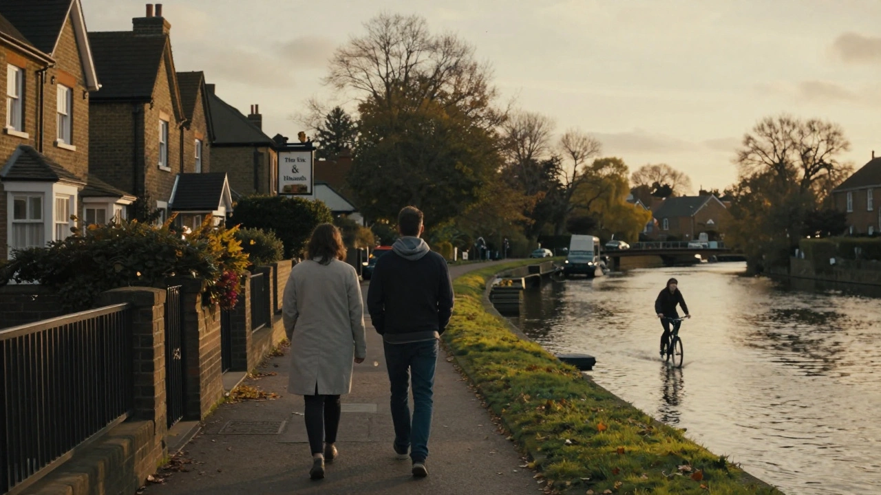 Two people stroll peacefully along the River Lea in Enfield Town at dusk, passing quiet homes and a local pub.
