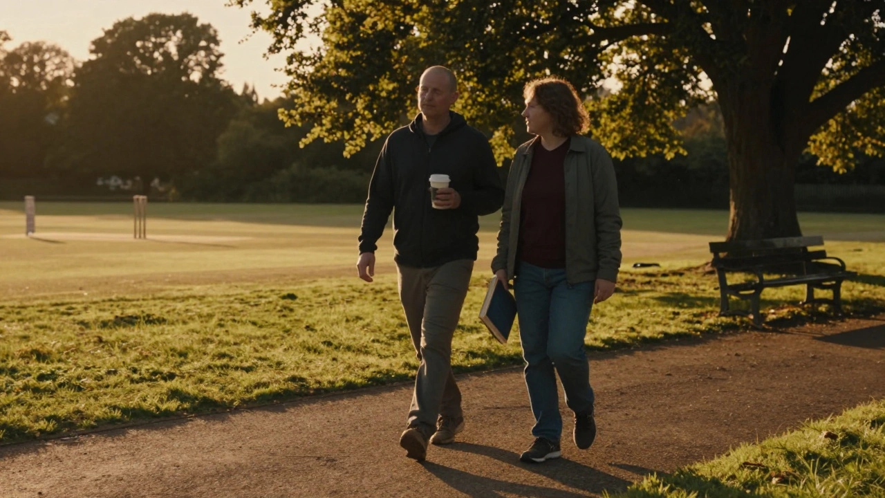 Two people walk peacefully along Monken Hadley Common at sunset, shadows stretching across the grass.